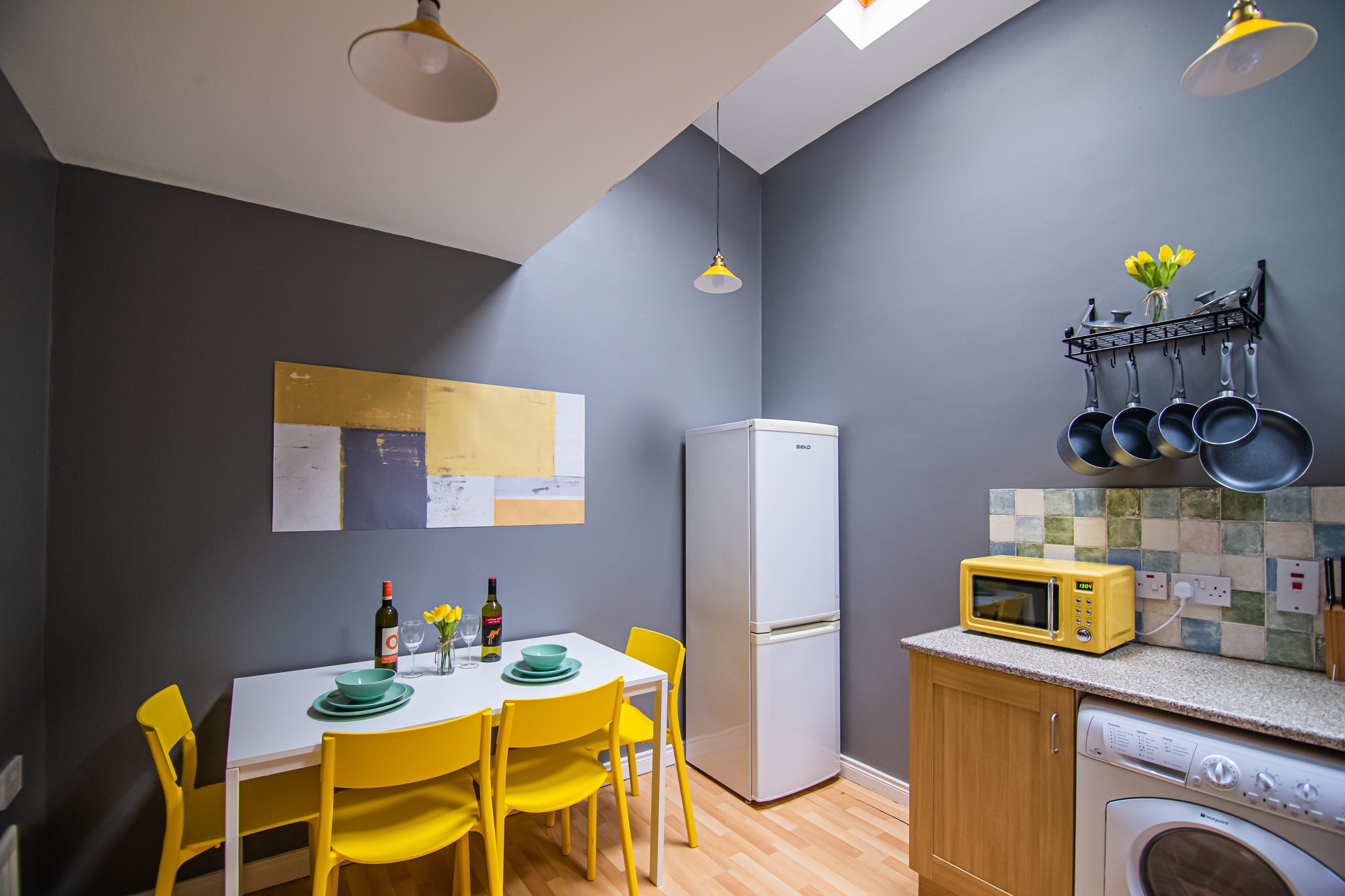 Kitchen and dining area with yellow chairs and appliances