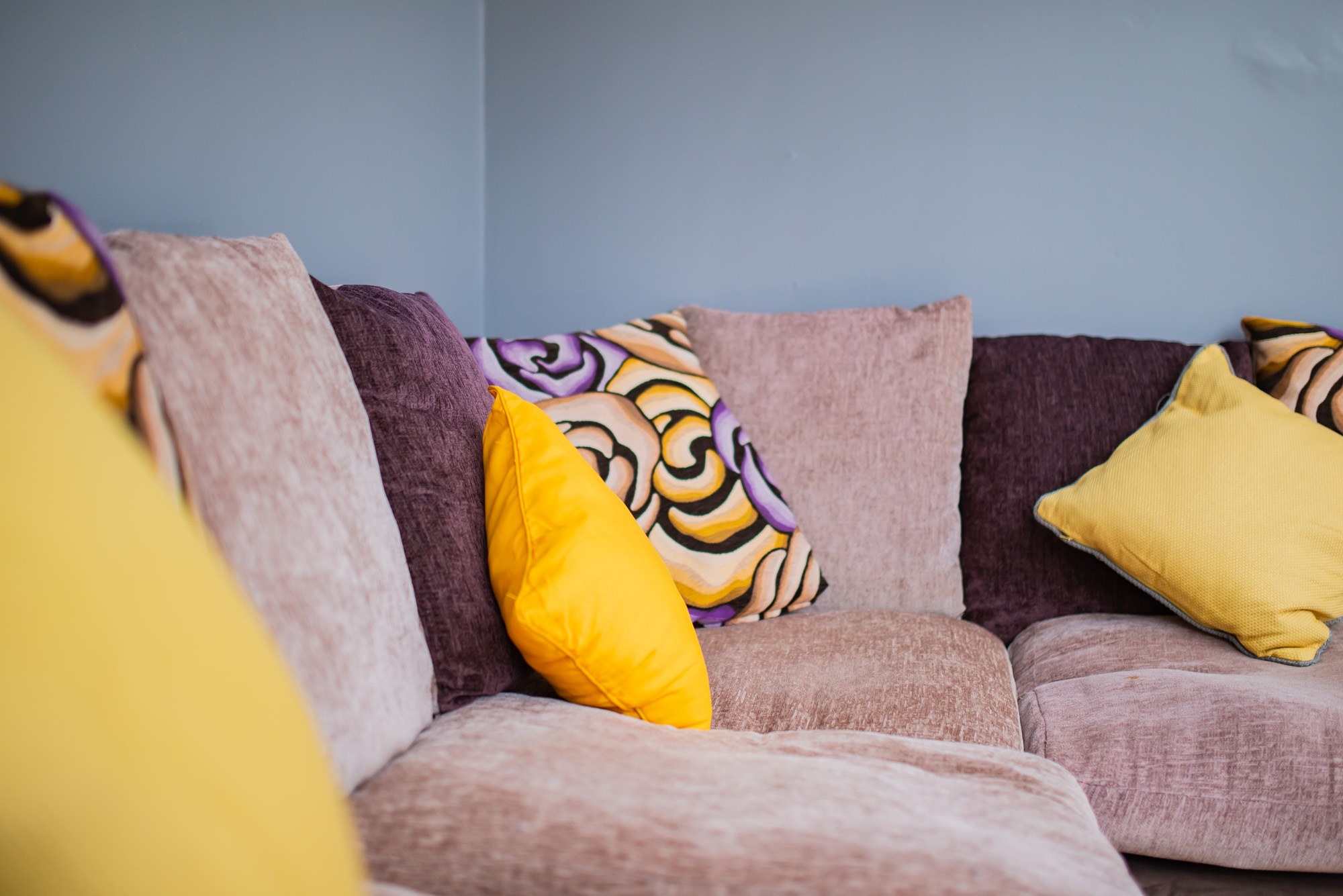 Corner sofa with yellow and patterned cushions