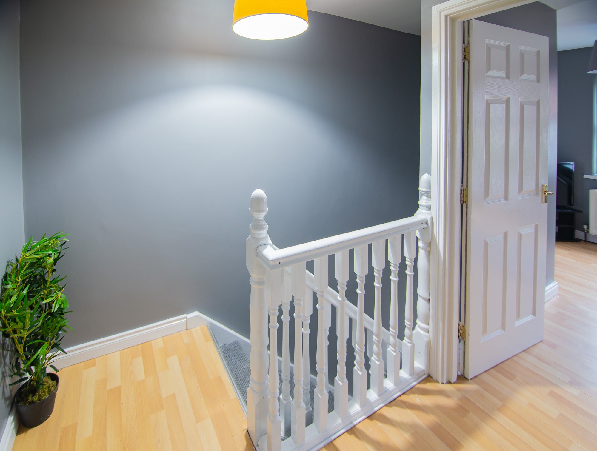 Stair landing with white rail and doorway